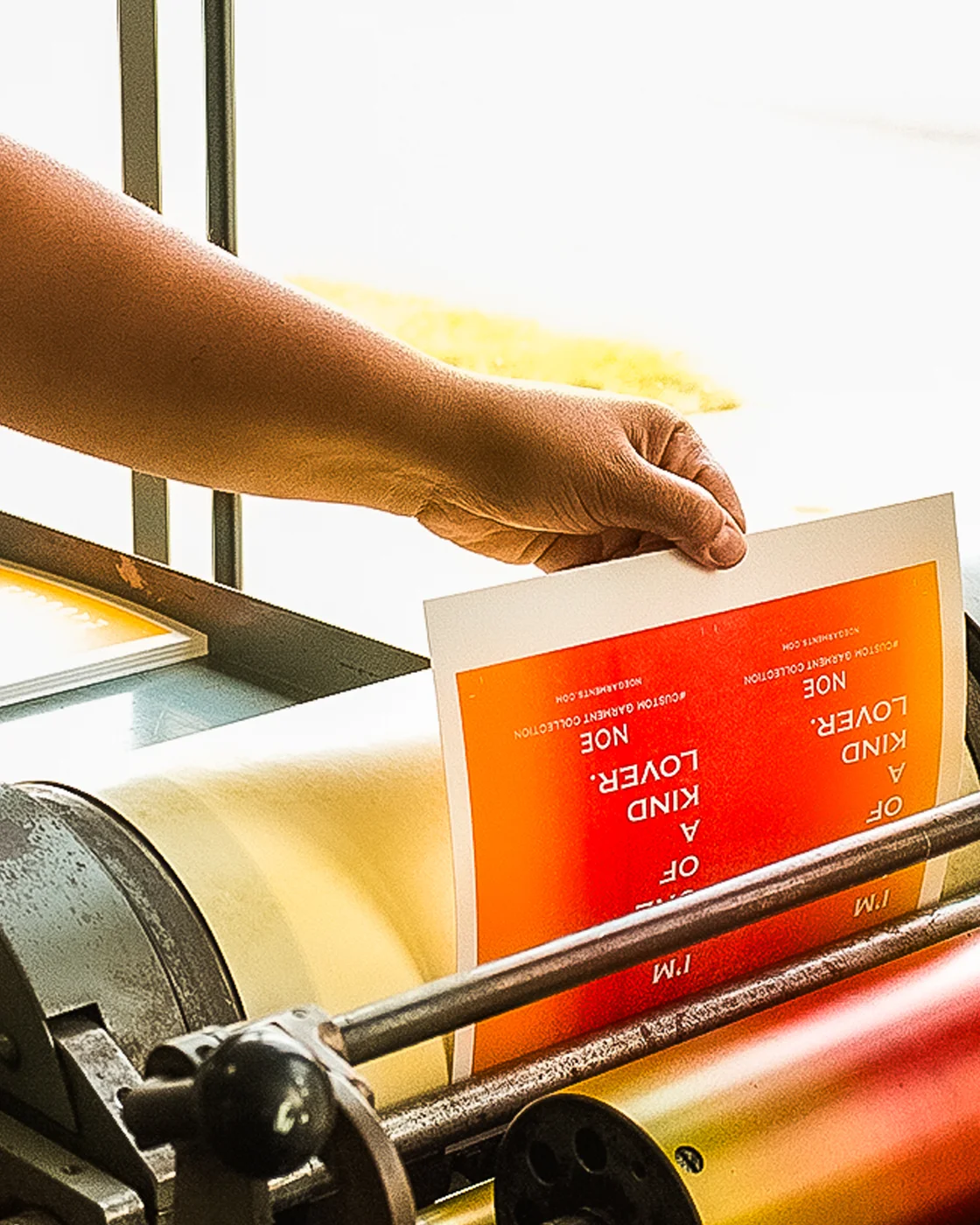 Leslie holding a rainbow letterpress print fresh off the press