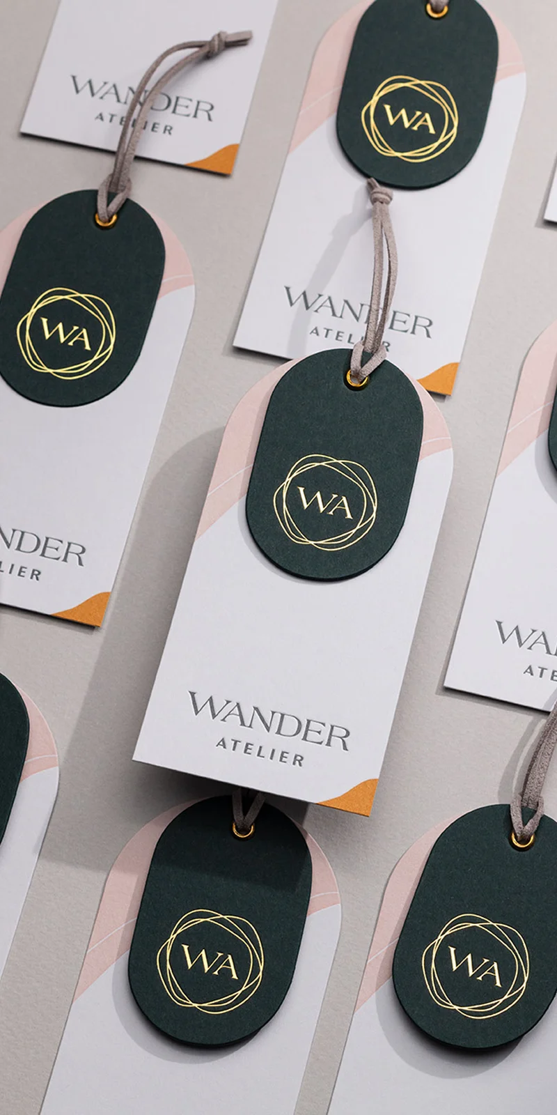 Custom hang tags with letterpress printing, gold foil stamping, and metal eyelets on heavyweight cotton paper