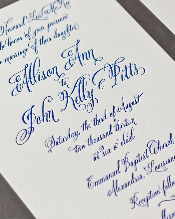 Letterpress wedding invitation printed in cobalt blue on cream cotton stock with elaborate flourished copperplate calligraphy
