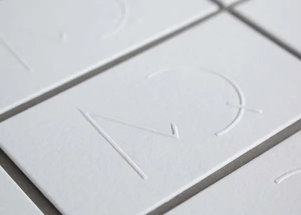 Minimalist embossed and letterpress business cards on white Crane's Lettra cotton paper