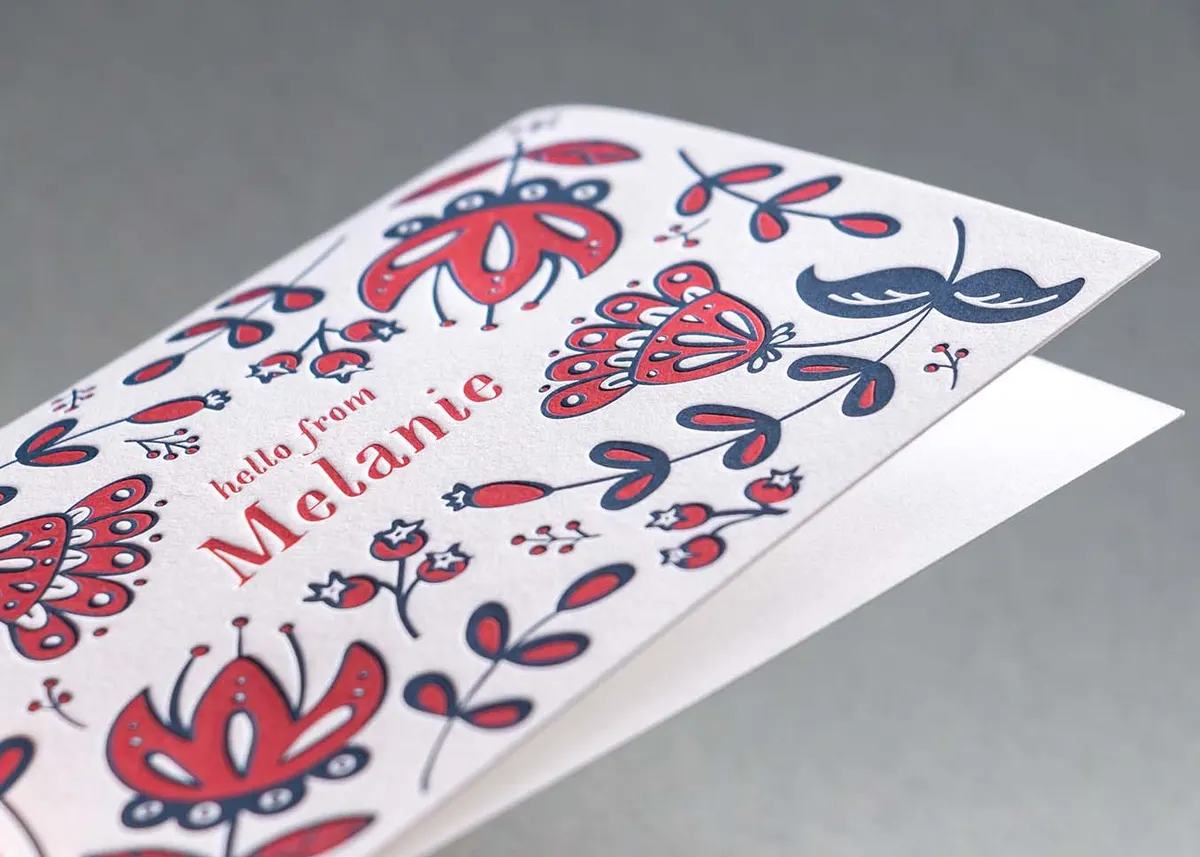 Letterpress note card tucked inside a red envelope showing return address printing