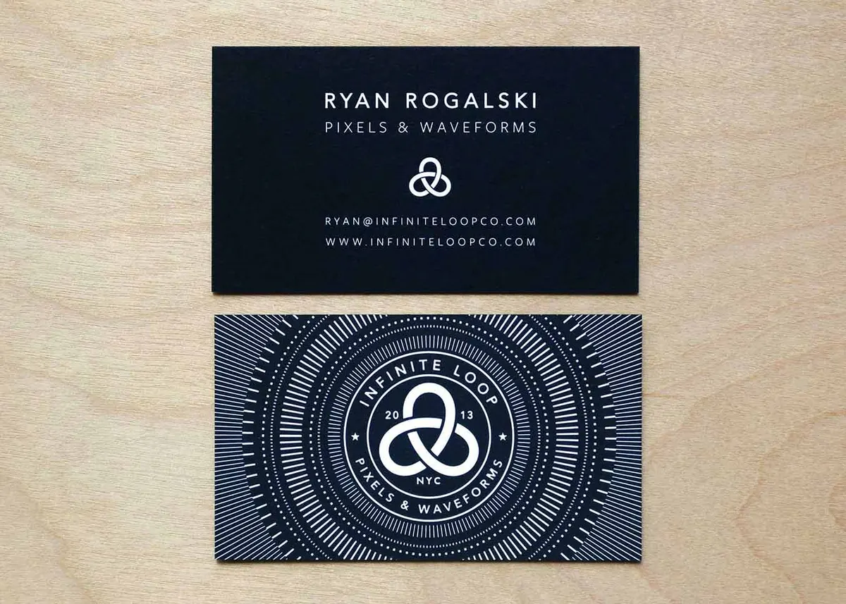 Close-up of the white foil geometric pattern on black business card showing fine line detail